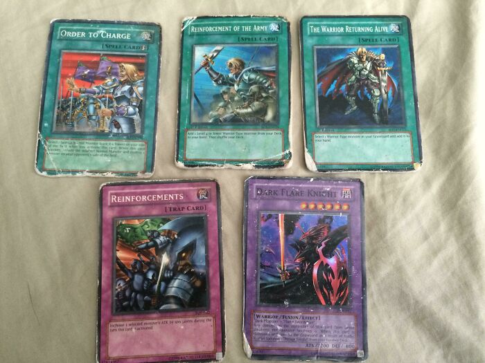 Five nostalgic 2000s trading cards including "Dark Flare Knight" and spell cards, showcasing popular childhood collectibles.