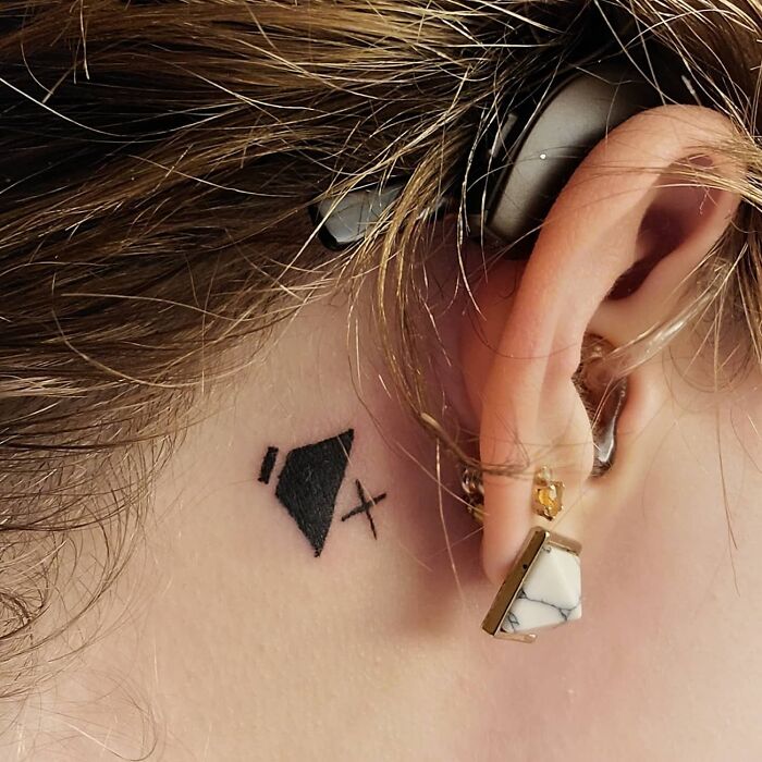 Simple tattoo idea of a speaker icon behind the ear, showcasing unique first tattoo inspiration.