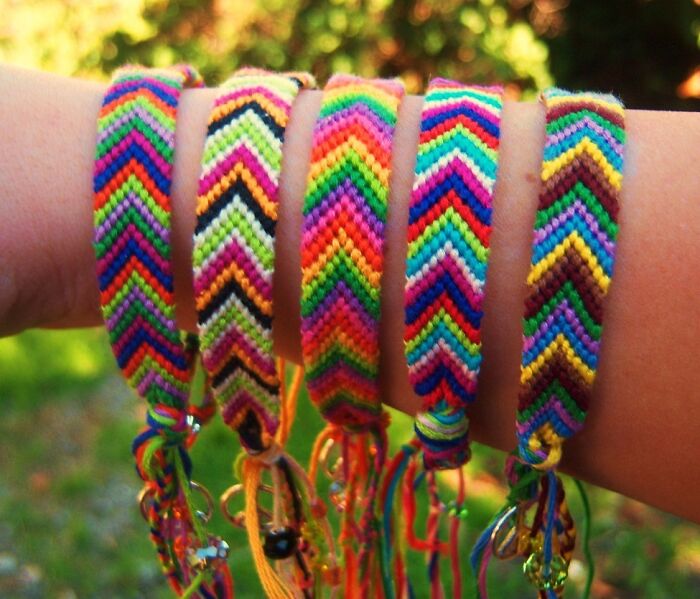 Colorful friendship bracelets, iconic 2000s nostalgia, displayed on a wrist in an outdoor setting.