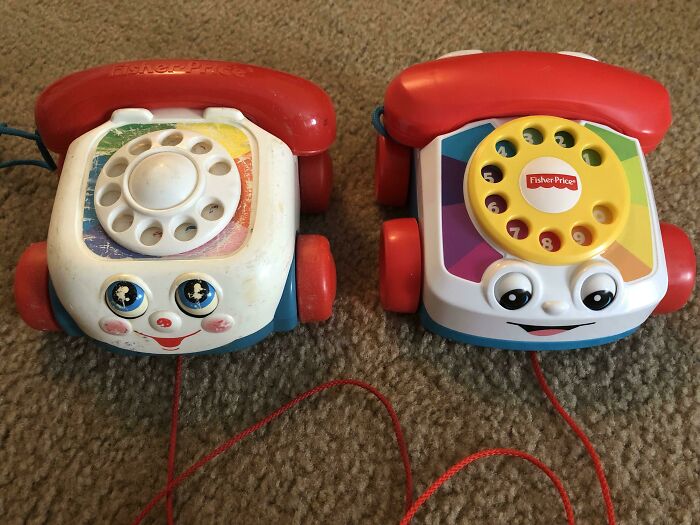 Two Fisher-Price rotary toy phones on carpet, evoking 2000s nostalgia.