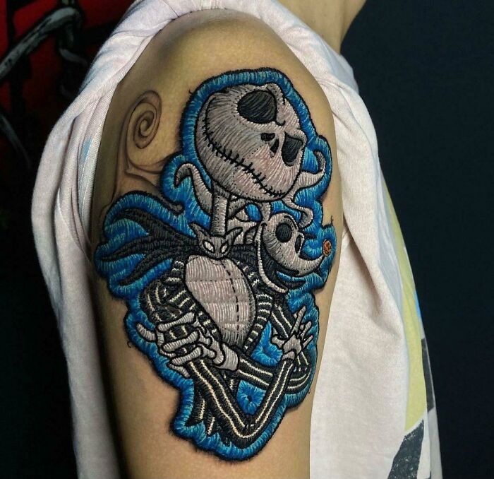 Intricate first tattoo idea showcasing embroidered skeleton characters on the arm.