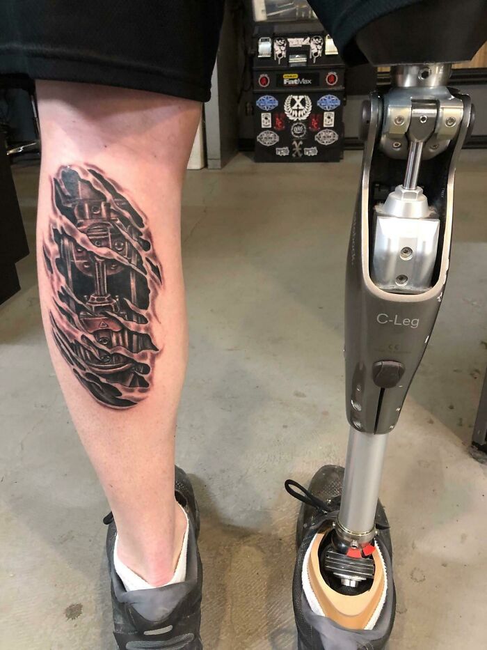 Intricate first tattoo on leg with prosthetic, featuring a detailed design.