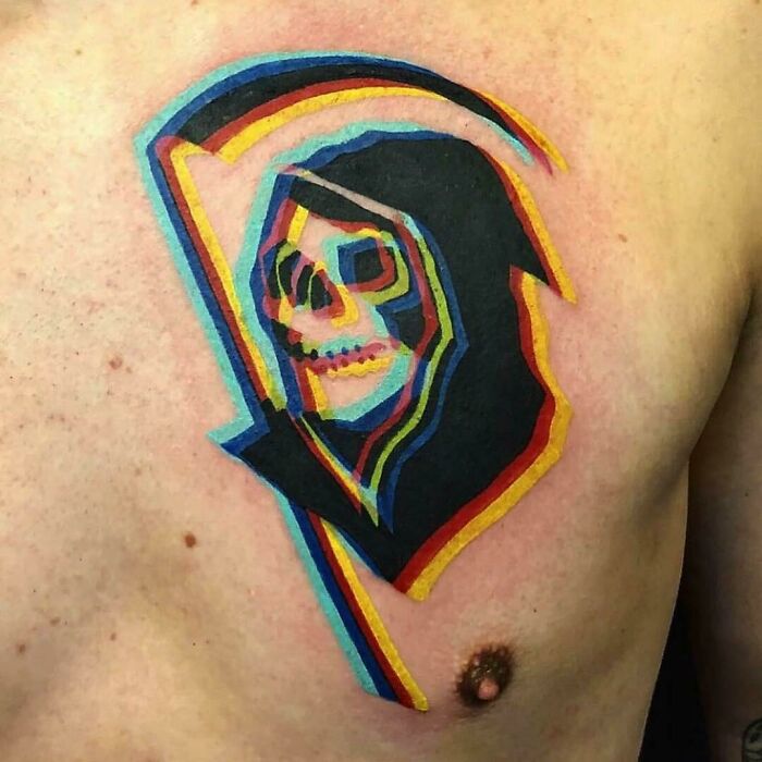 Colorful grim reaper tattoo on chest, showcasing vibrant and spooky Halloween tattoo art.