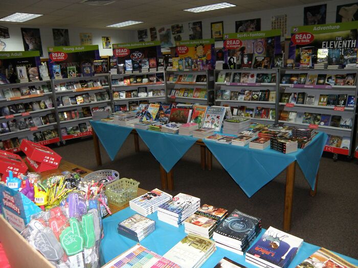 2000s bookstore display with novels, comics, and school supplies, evoking nostalgia for early 2000s book fairs.