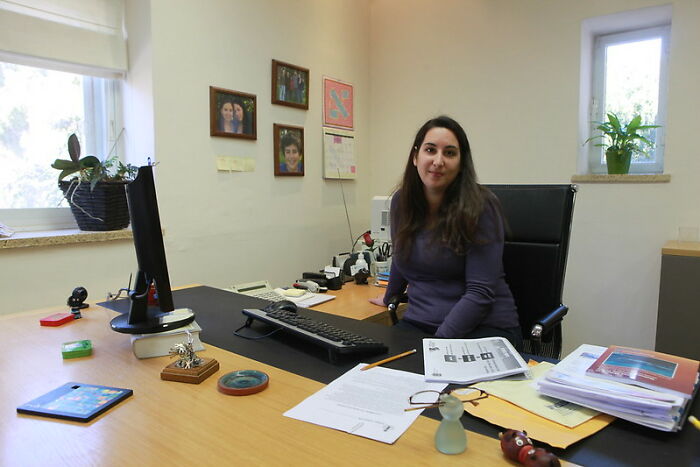 Woman sitting at office desk with computer and documents, illustrating someone in this online group dodged a huge tactical nuke.