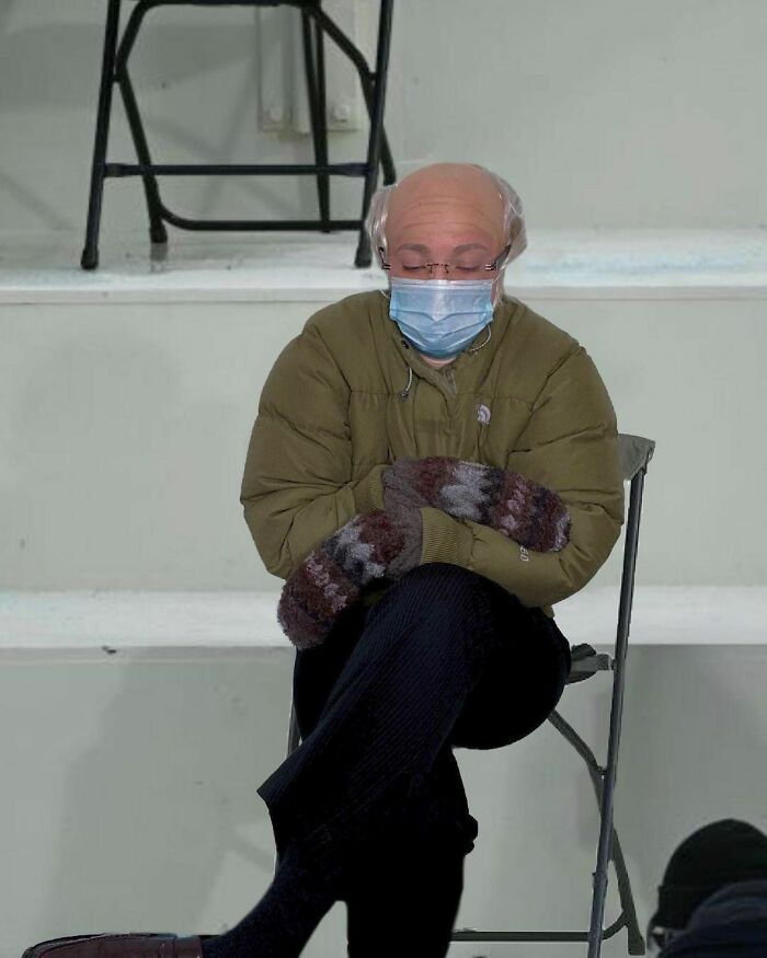 Person sitting with crossed legs wearing a simple Halloween costume featuring mittens and a bald cap, showing creative effort.