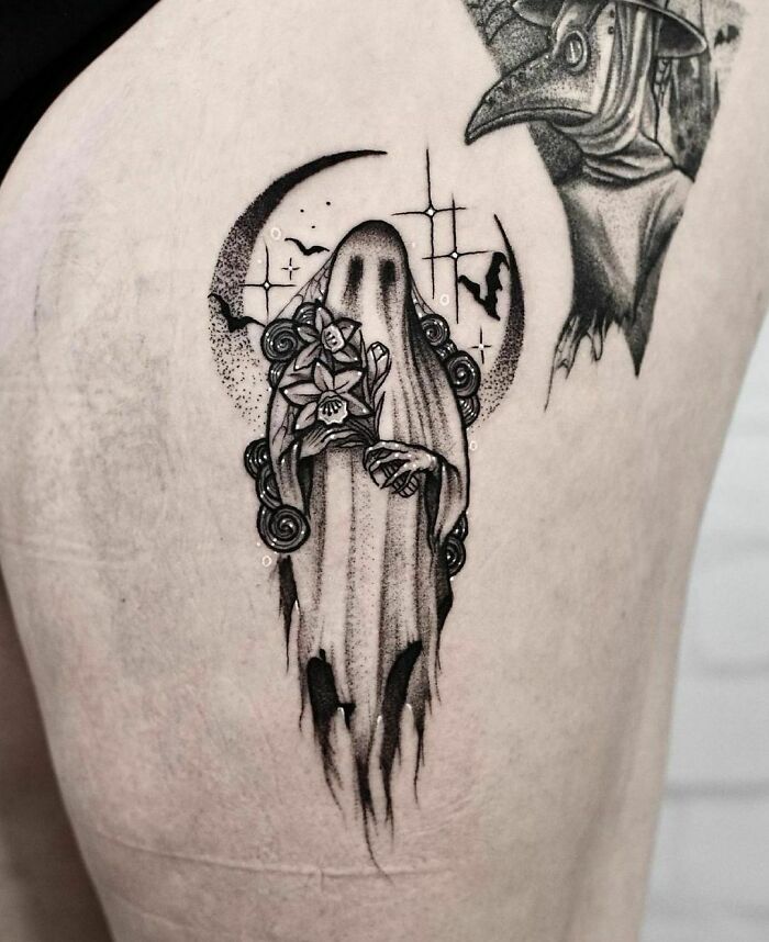 Spooky Halloween tattoo featuring a spectral figure holding flowers with a moonlit background.