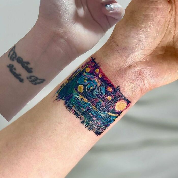 Colorful tattoo makeover on a wrist, transforming an old design into a vibrant, artistic piece by ink masters.