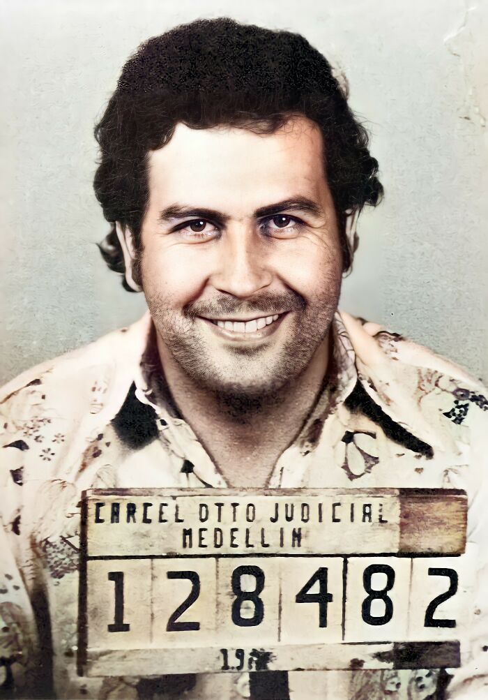 Restored vintage mugshot of a famous man smiling, holding a Medellin judicial prison identification board.