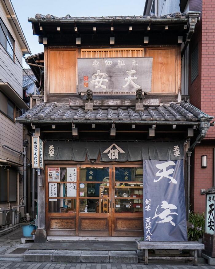 Traditional old architecture in Japan showcasing wooden structures and tiled roofing in an urban setting with modern buildings nearby.