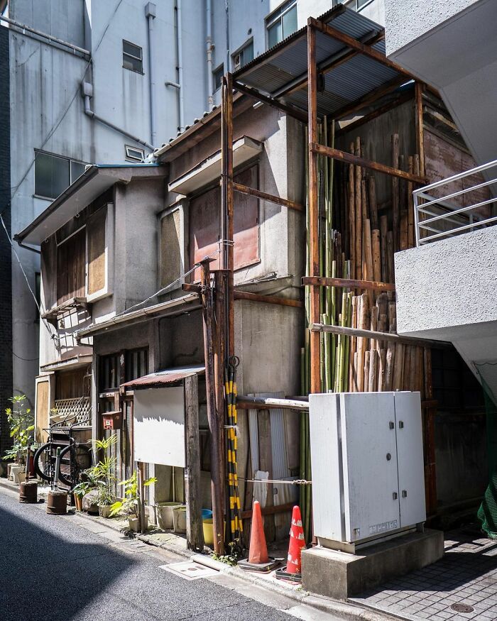 Old architecture in Japan showing a traditional building with weathered wooden elements amid modern urban structures.