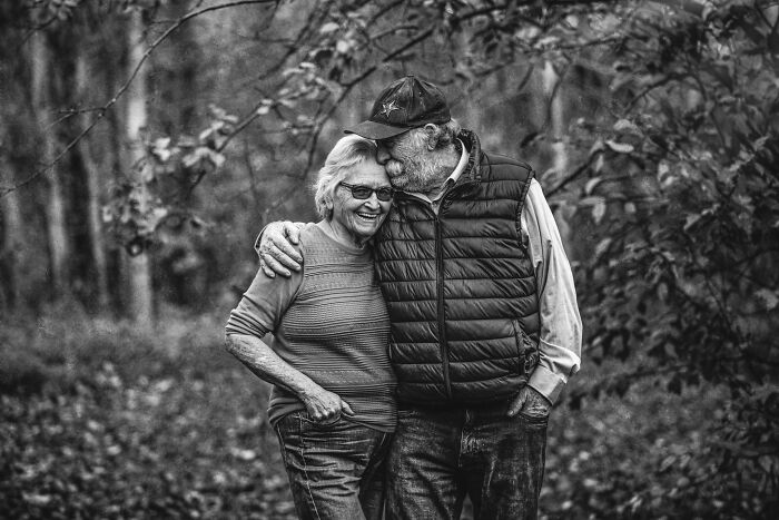 Elderly couple in love smiling and embracing outdoors, captured in one of the best photos of couples in love.
