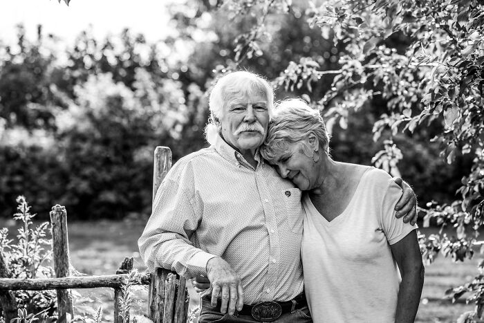 Elderly couple in love embracing outdoors, captured in a heartfelt picture showing genuine affection and connection.