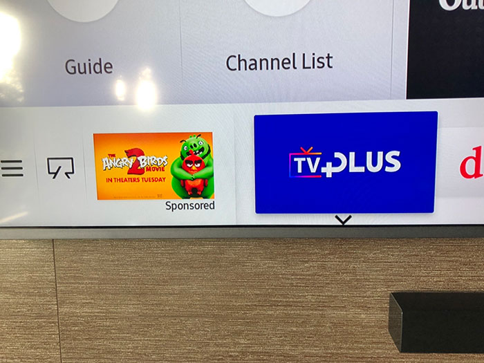 TV interface showing sponsored ad for Angry Birds movie and TV Plus app, illustrating evil marketing techniques in digital media.