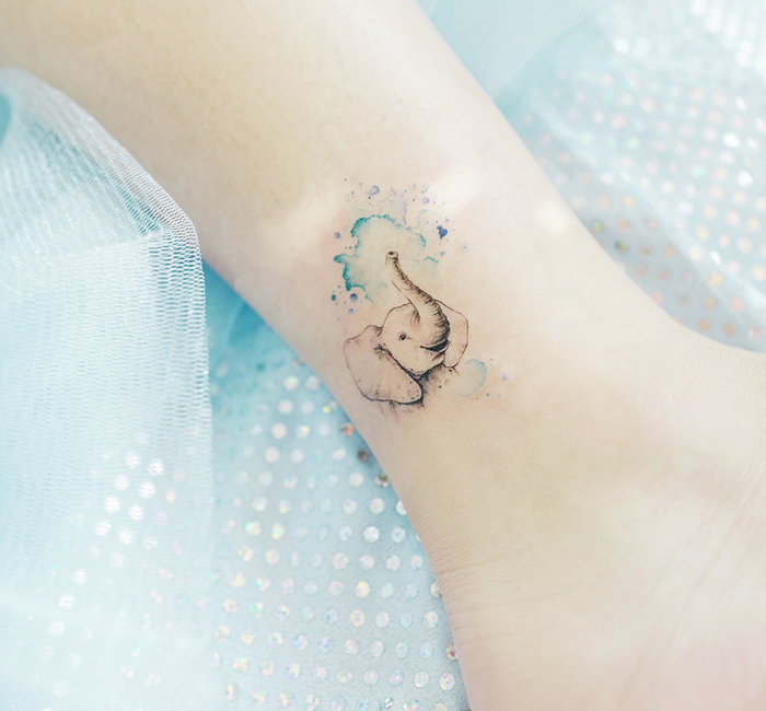 Elephant tattoo on ankle with watercolor effect, showcasing an interesting first tattoo idea.