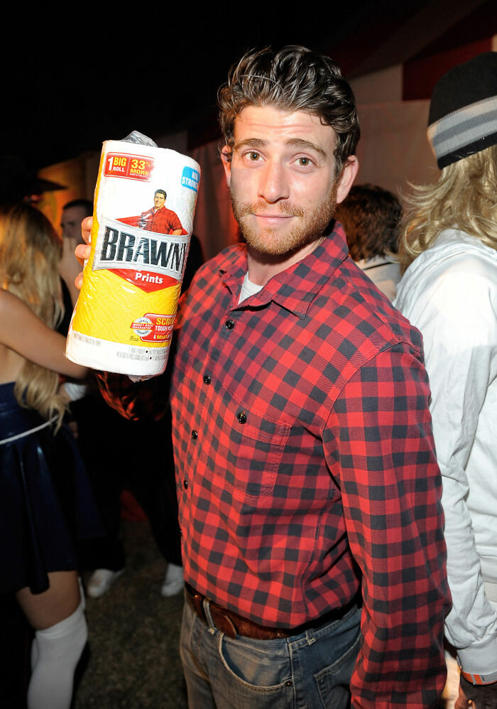 Man in a red plaid shirt holding a roll of paper towels as a simple Halloween costume with minimal effort.