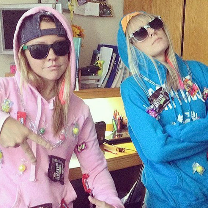 Two people in casual Halloween costumes with candy taped to hoodies and sunglasses, showing effortless creative costume ideas.