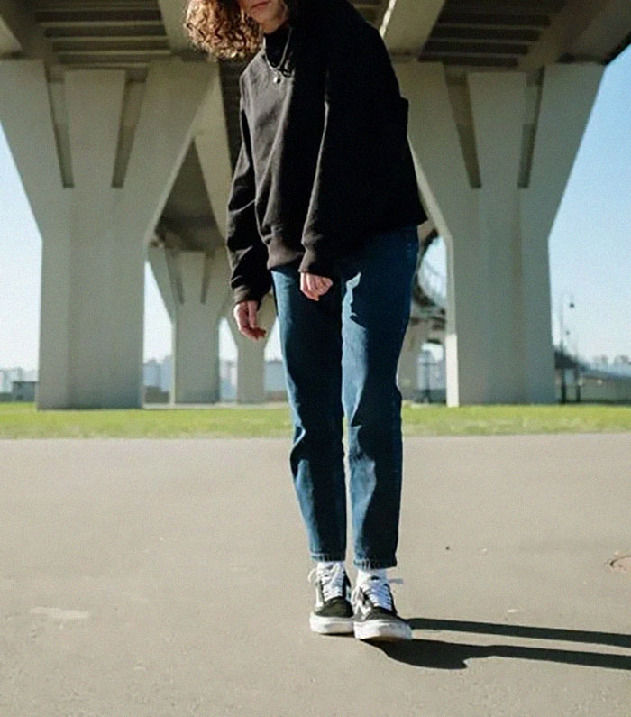 Person wearing casual clothes standing under a bridge during the day, representing the ugly side of pretty privilege.