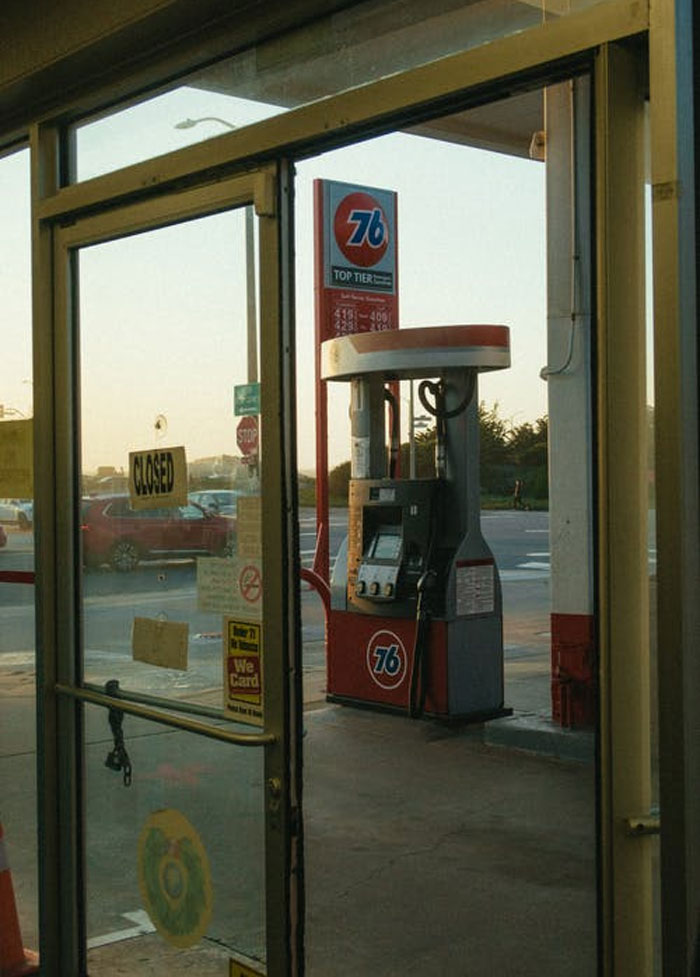 Gas station pump visible through a glass door with a closed sign, illustrating the ugly side of pretty privilege.