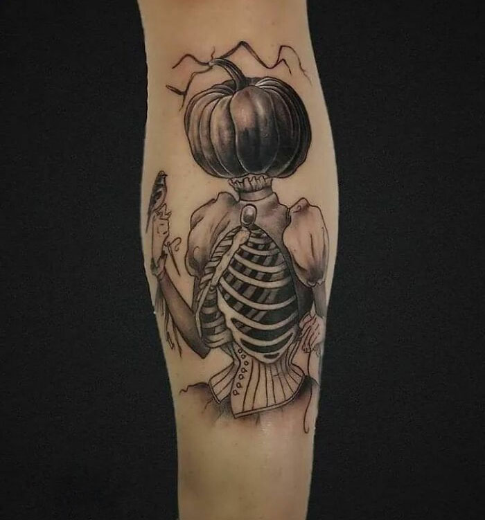 Spooky Halloween tattoo of a pumpkin-headed figure with skeletal ribcage and vintage attire.