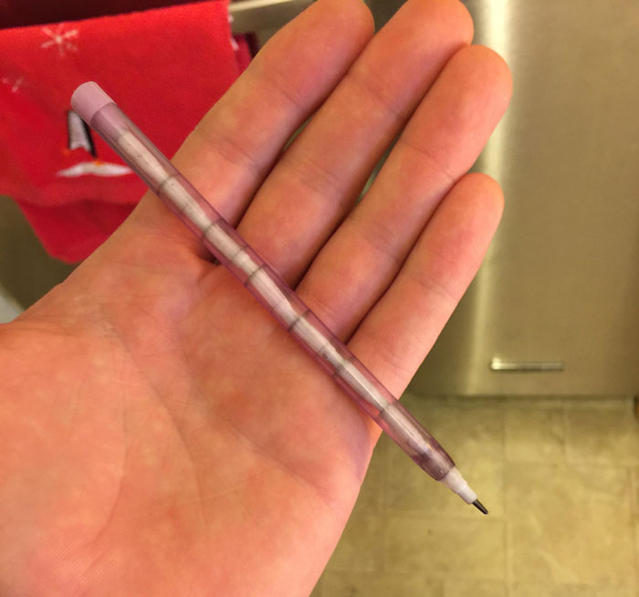 Nostalgic 2000s item: a clear purple mechanical pencil held in hand.