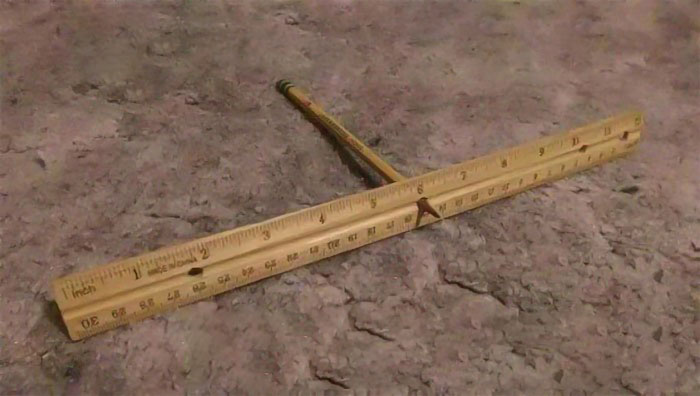 Wooden ruler and pencil spin game, a nostalgic 2000s classroom pastime on a textured surface.