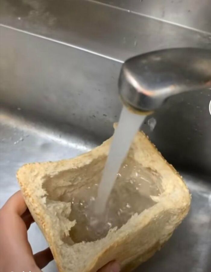 Pouring water into a hollowed-out bread loaf, illustrating a joke about drinking water.