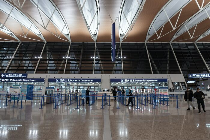Empty airport terminal with few travelers at domestic departures, reflecting a calm scene related to disturbing facts shared to ruin your day.