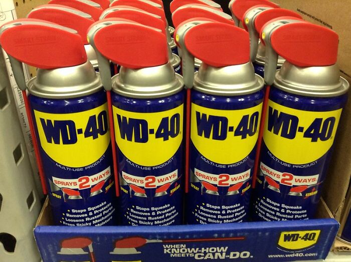 Cans of WD-40 multi-use product with red spray top, displayed in a store shelf, popular product worth the money.