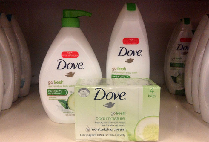 Dove go fresh cool moisture body wash and soap bars displayed on store shelf, highlighting brand slogans and packaging.