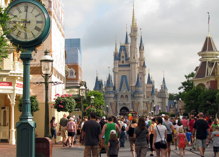 Crowd walking toward a famous castle with a street clock, depicting sarcastically honest slogans about famous brands.