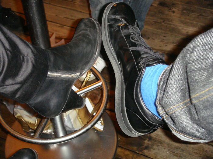Close-up of two people showing different shoes in an online group discussion about products worth the money.