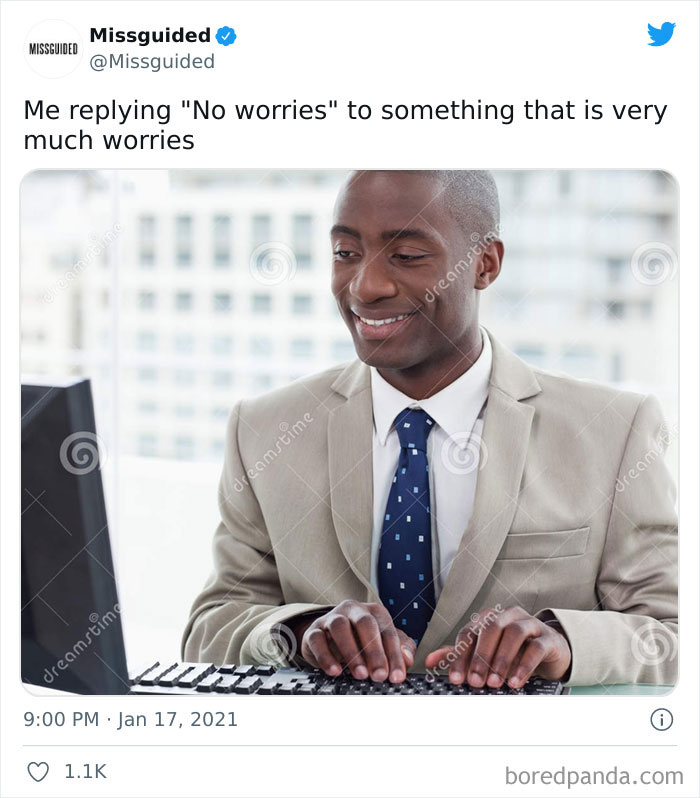 Man in beige suit typing on keyboard with a smile, illustrating relatable work-related memes about office life humor.