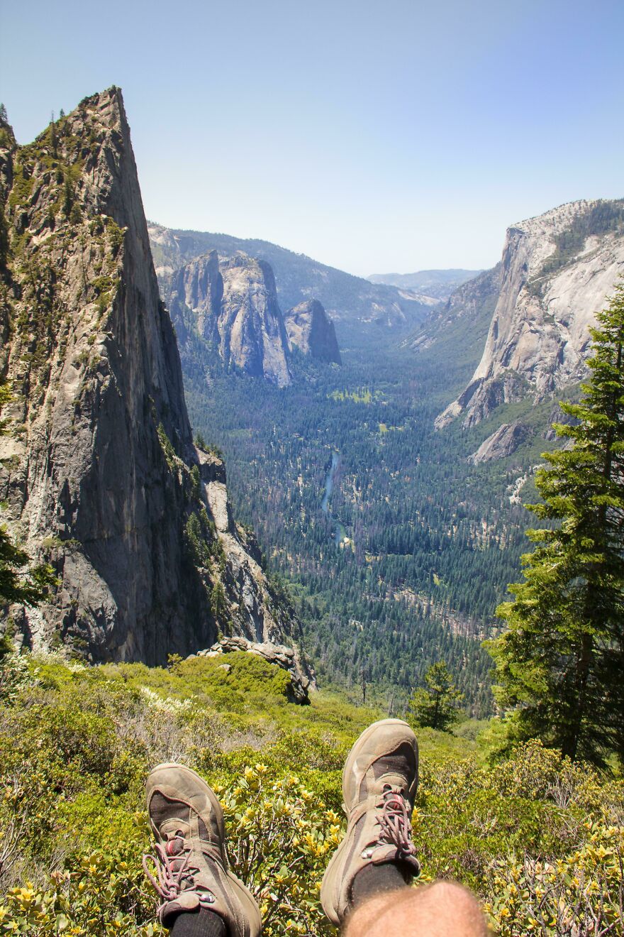 Person relaxing with hiking boots, enjoying breathtaking mountain scenery.