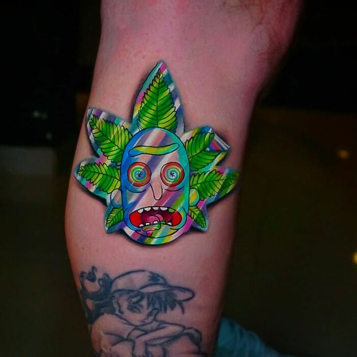Holographic sticker tattoo featuring a colorful face with leaf patterns, designed by a Brazilian artist.