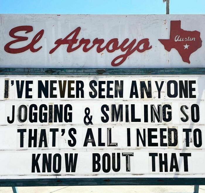 Humorous sign at El Arroyo restaurant in Austin, Texas, joking about jogging and smiling.