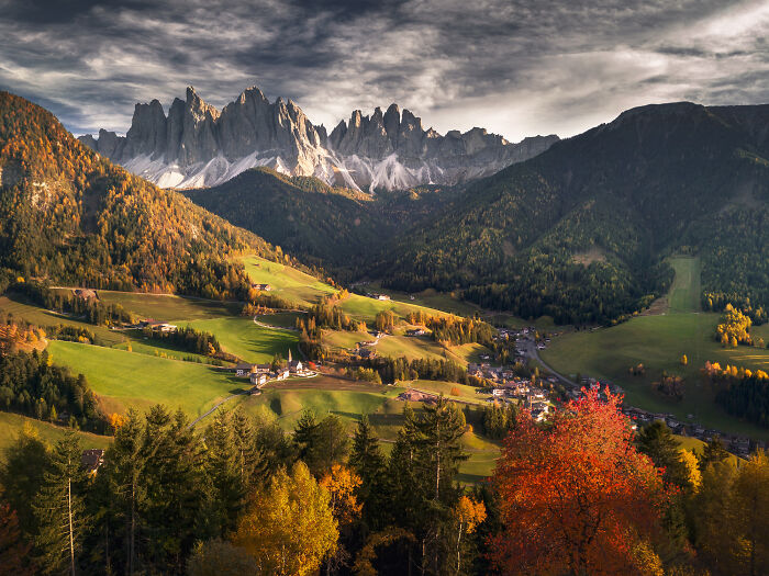 Colorful fall landscape in the Alps with dramatic mountain peaks and autumn trees captured by mountain photographer.