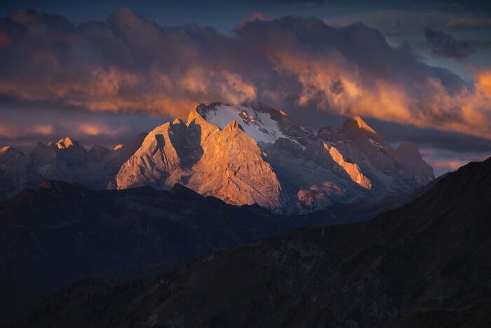 Alps mountain landscape at sunset with dramatic clouds, showcasing colorful fall hues in a mountain photography scene.