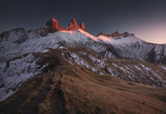 Alps mountain landscape at sunrise with colorful fall foliage and snow-covered peaks captured by mountain photographer.