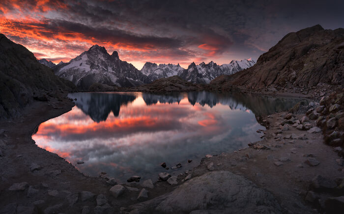 Mountain photography in the Alps featuring a vibrant colorful fall sunset reflected in a serene mountain lake.