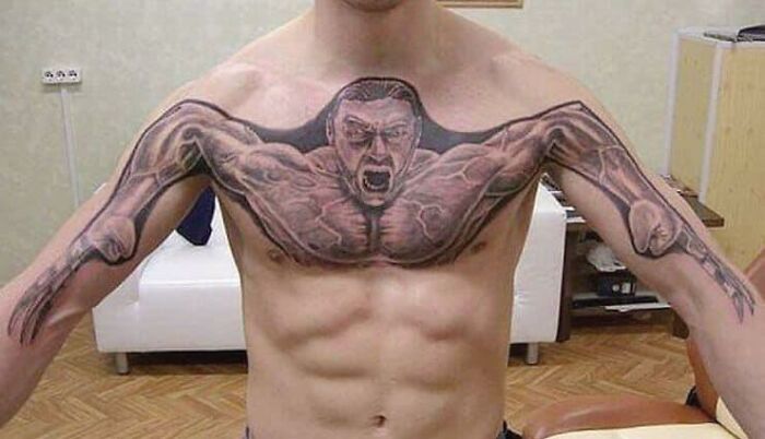 Man with unusual chest tattoo featuring muscular figure, showcasing inkshaming creativity.
