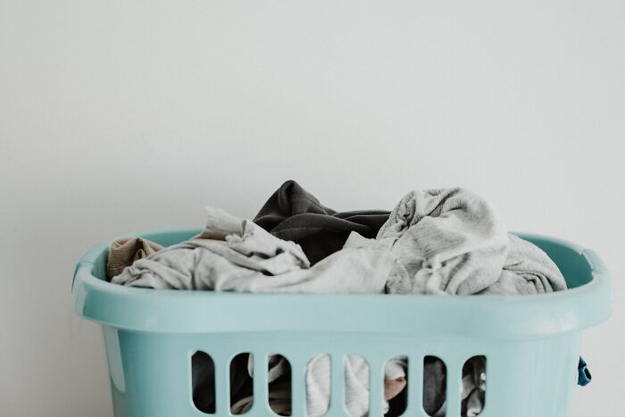 Laundry basket filled with clothes, illustrating common household spots burglars suggest avoiding to hide your stuff.