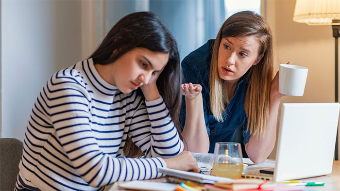 Two women discussing and studying together, illustrating challenges faced by people labeled as gifted in life.