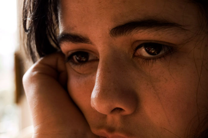 Close-up of a thoughtful person reflecting on life after being labeled gifted during childhood.