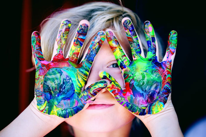 Child with hands covered in colorful paint, symbolizing the vibrant and complex aspects of married life advice.