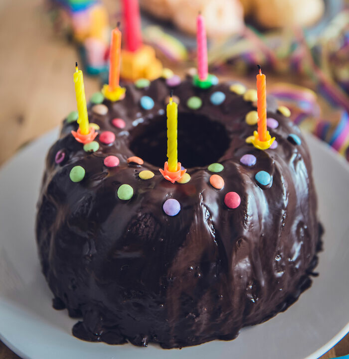 Chocolate bundt cake with colorful candles and sprinkles, symbolizing social tips to help you connect with others online.