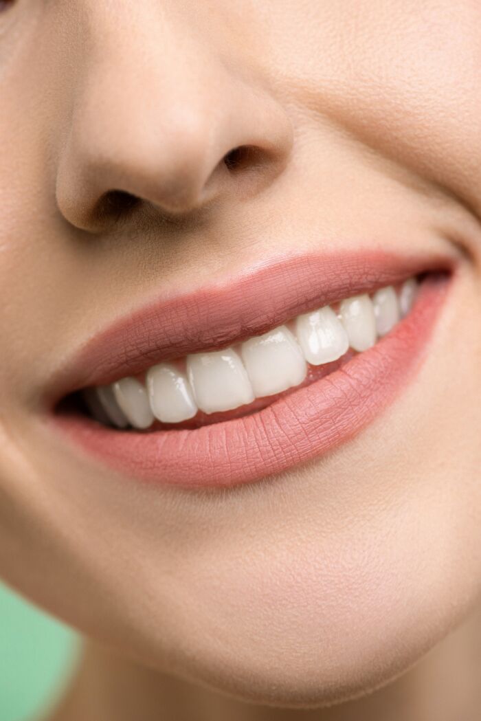 Close-up of a smiling person showing teeth, illustrating useful social tips to help connect with others.
