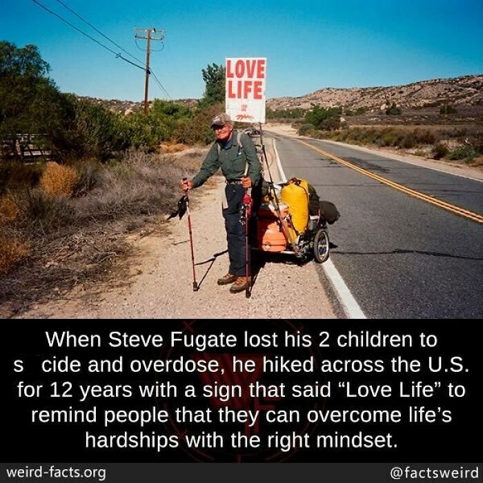 Man hiking across a road with a cart and Love Life sign, illustrating weird facts about the world and resilience.