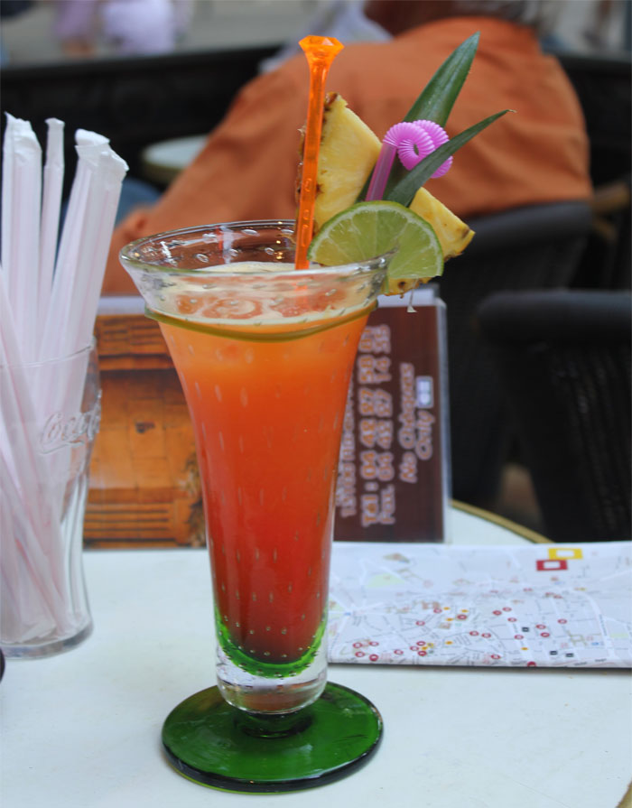Colorful tropical cocktail with pineapple and lime garnish, illustrating bartenders sharing drink orders and personality insights.