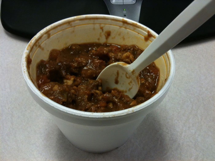 Styrofoam cup filled with prison food chili and a plastic spoon, illustrating incarceration experiences and former prisoners' insights.